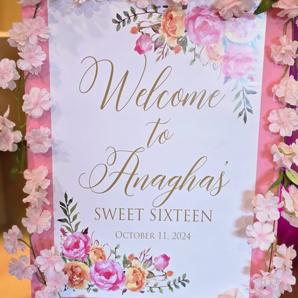 Welcome sign for Anagha's Sweet Sixteen, adorned with pink and orange floral designs.