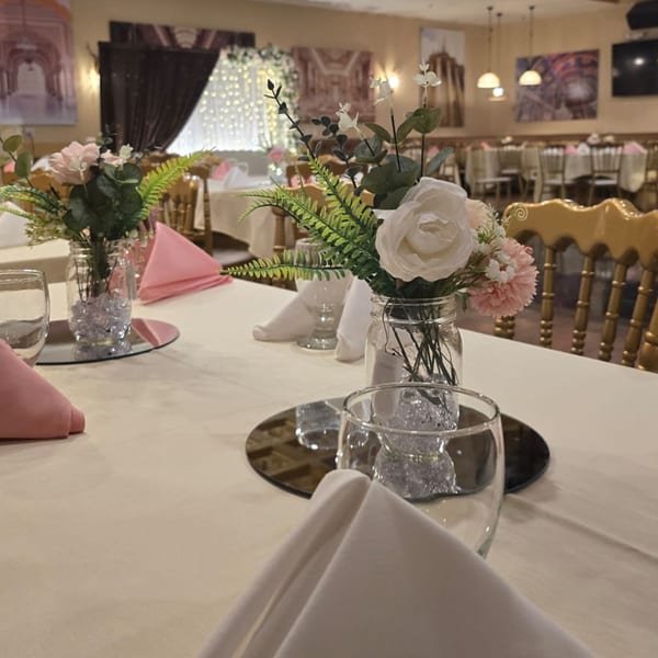 Elegant dining room at Spice Culture with floral centerpieces, golden chairs, and decorative lighting.