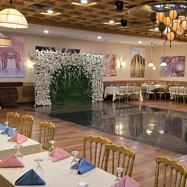 Spice Culture's elegant Indian restaurant interior with a floral wall, dining tables, and a dance floor.