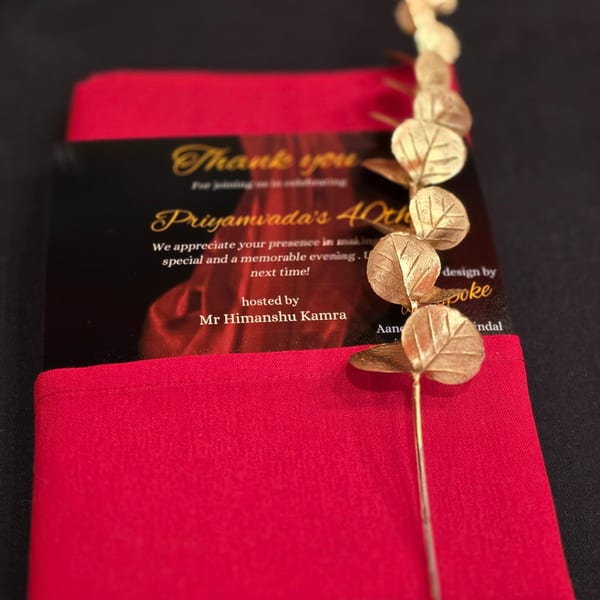 A black and red thank you card for Priyamvada's 40th birthday, adorned with golden leaf decorations.
