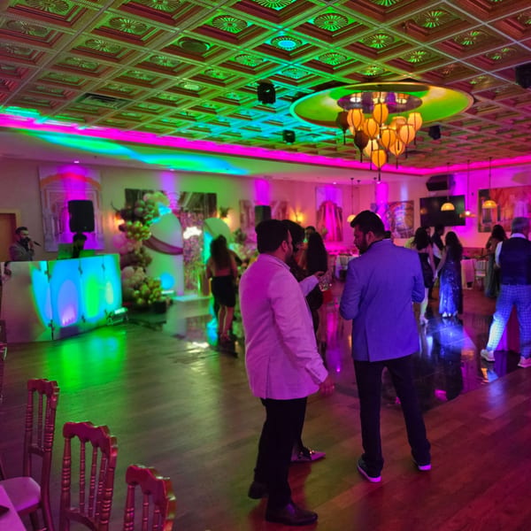 Guests socialize and dance in a vibrant, neon-lit event space at Spice Culture.