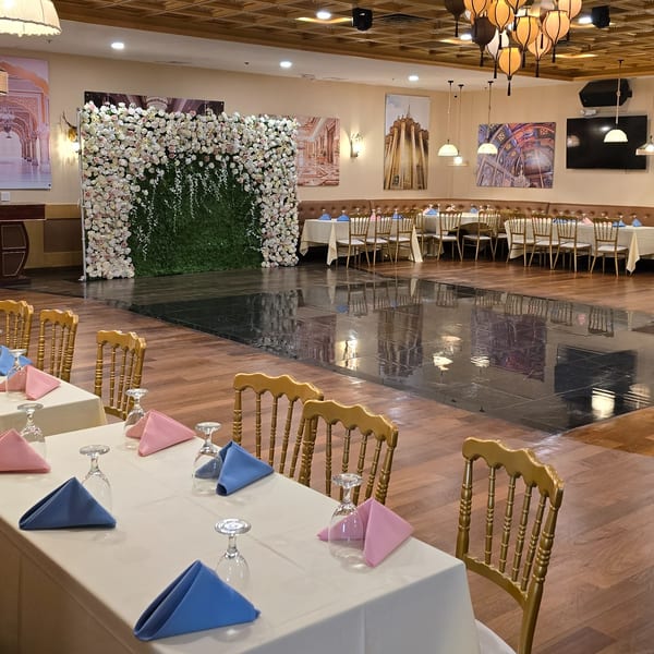 Spice Culture's elegant dining room with set tables, a dance floor, and a floral wall decoration.