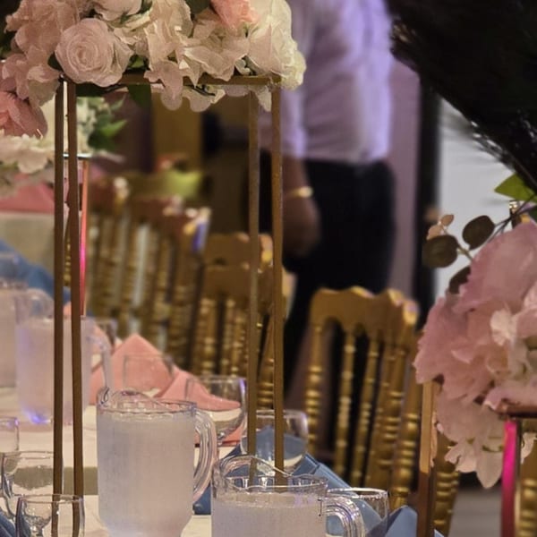 Elegant table setting with floral centerpieces, water pitchers, and golden chairs at Spice Culture.